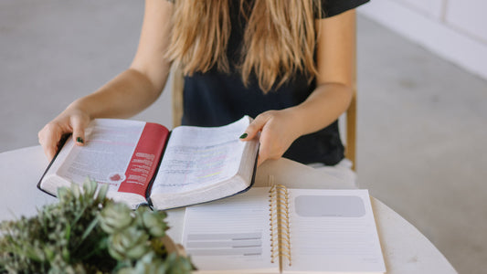 Woman studying her Bible with a Steadfast and Sustained Bible Notes journal