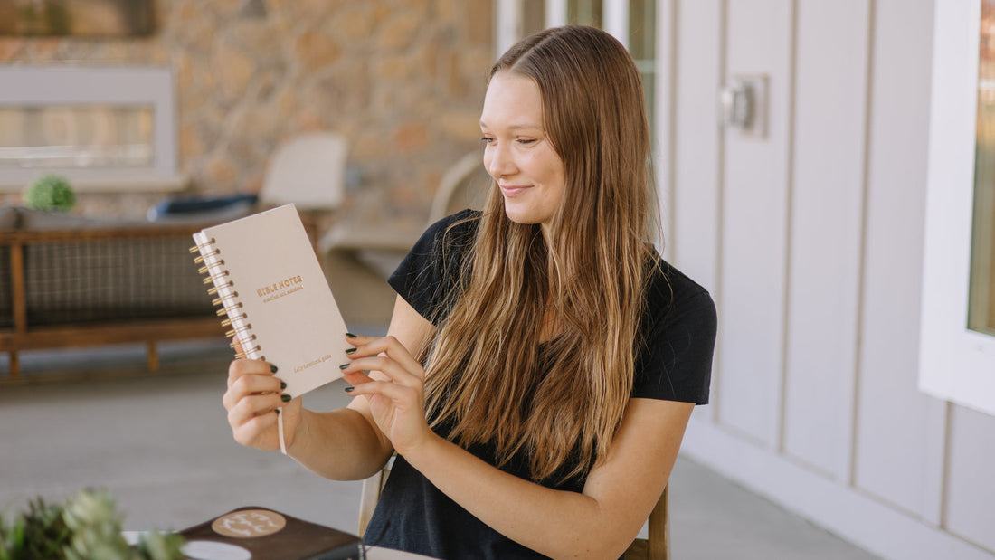 Woman holding the Steadfast and Sustained Bible Notes journal for Scripture study