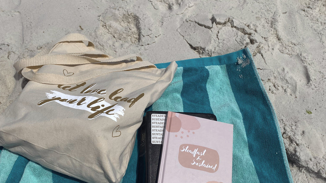 Bible, journal and tote at the beach for Steadfast and Sustained faith journaling