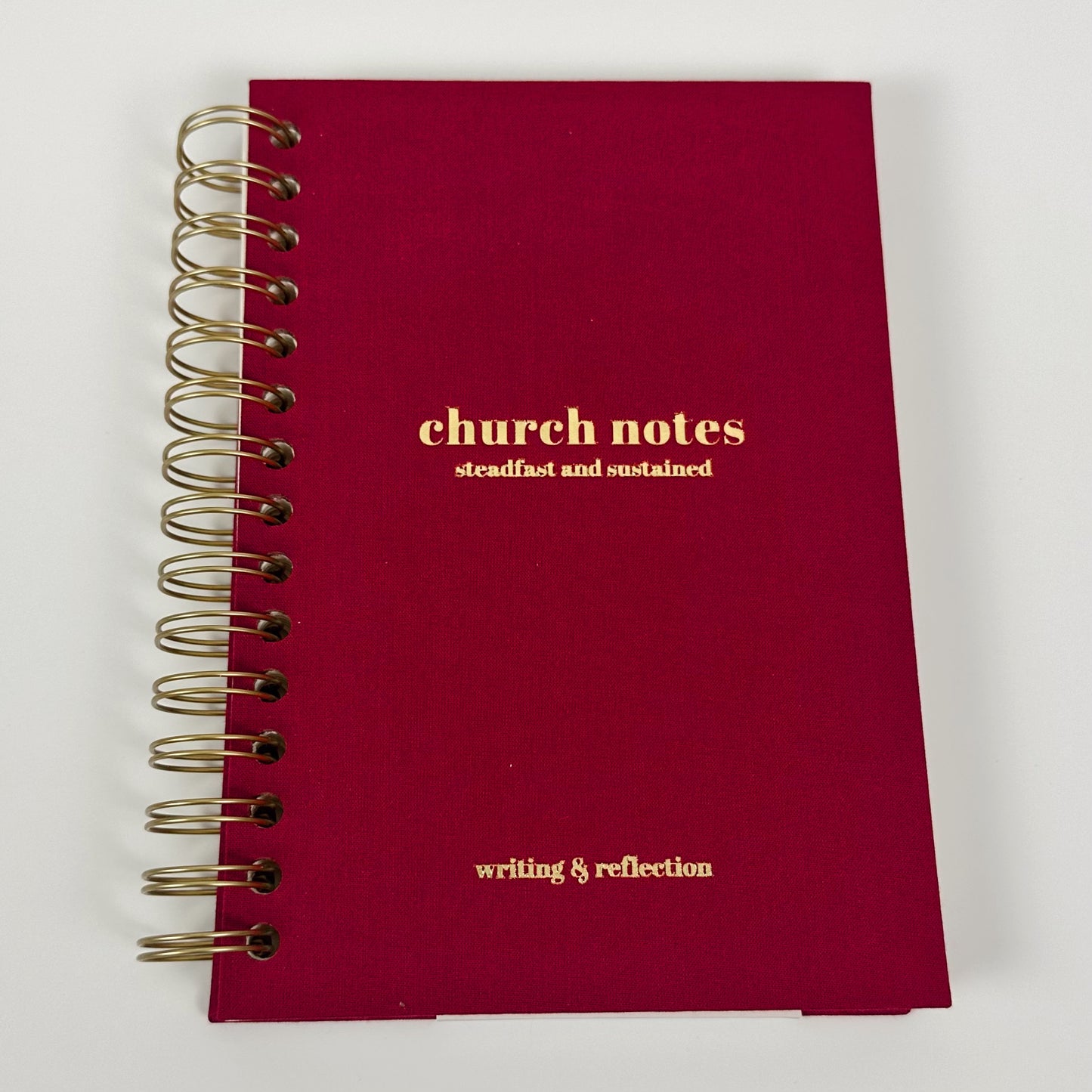 Red notebook with gold text on a white background