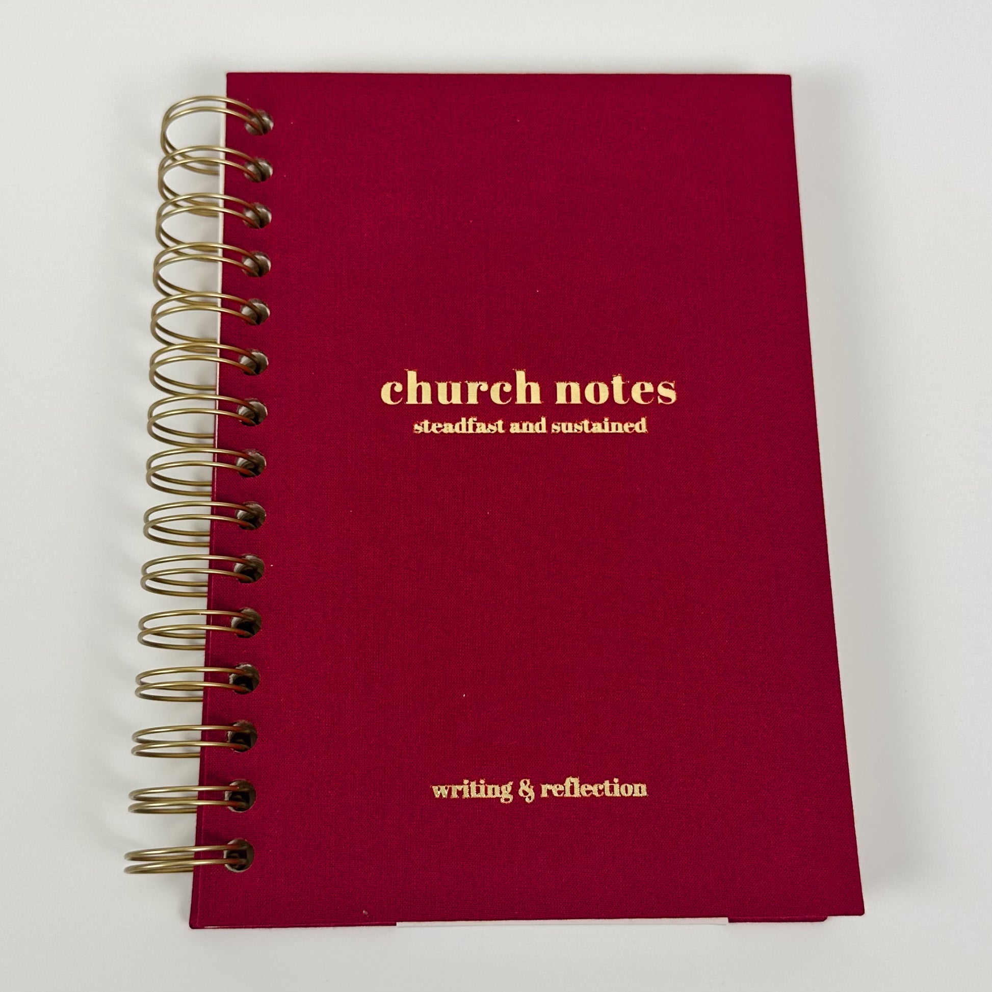 Red notebook with gold text on a white background